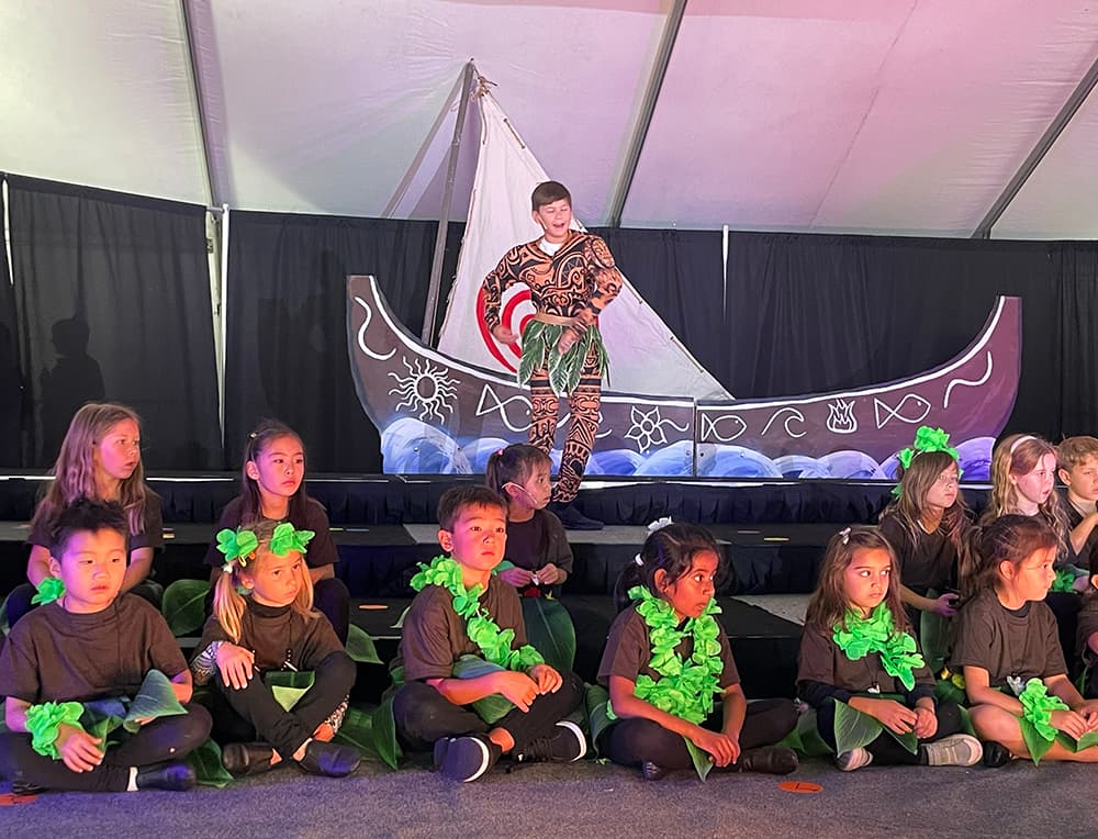 Students performing in costume on stage at Spring Sing