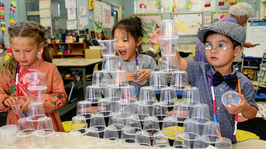 Kindergarteners stacking cups together during a themed classroom activity