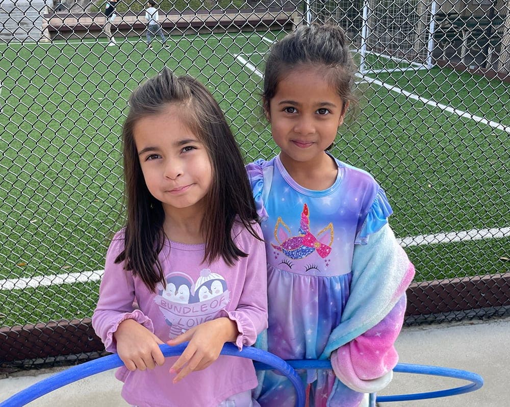 Two students with hula hoops on the field during After Care