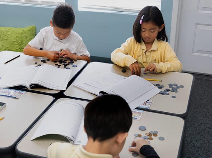 A student works with numbered math manipulative cards during small-group instruction
