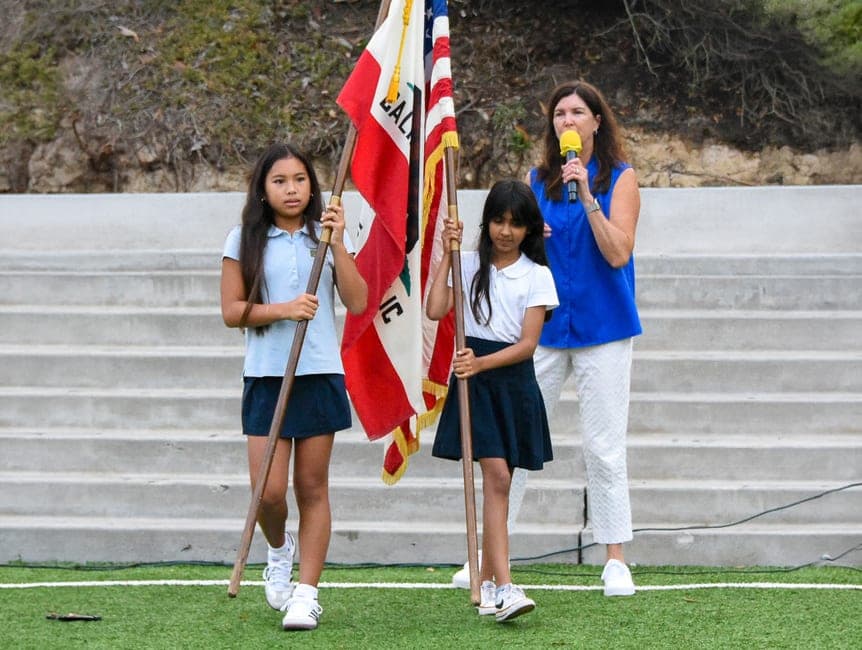 Sixth graders carrying the flags during an outdoor assembly