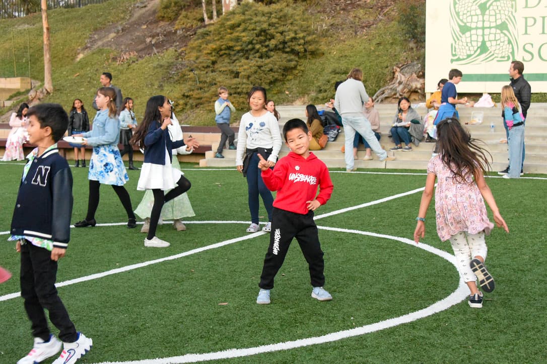 Students dancing on the field at the family dance party