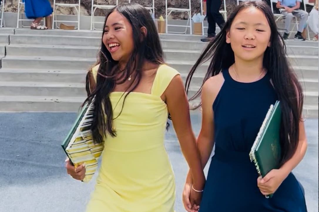 Two Del Mar Pines graduates walking together at commencement