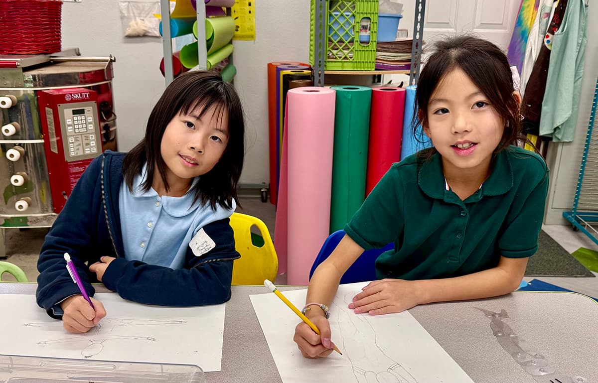 Two students drawing in the art room