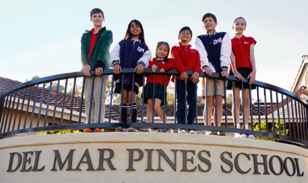 Del Mar Pines students in uniform standing at the school sign