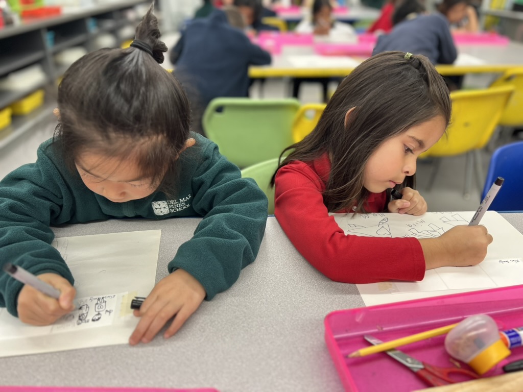 Two students writing at their desks in class.