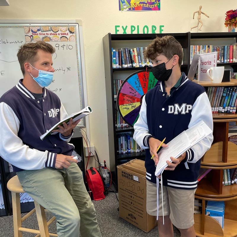 del mar pines student and teacher with masks talking in class